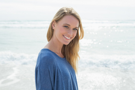 一个微笑的随便的女人在海滩的肖像