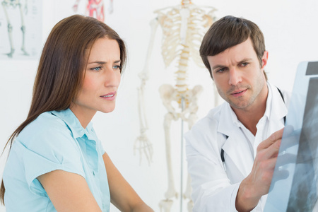 向女病人解释脊柱 x 射线的男医生