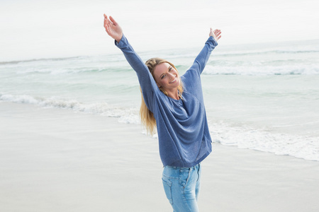 幸福的女人站在海滩上举手
