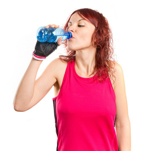 年轻的运动女孩喝水在白色的背景