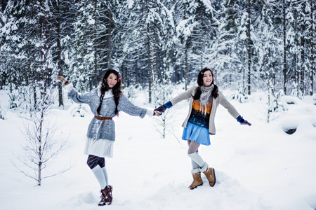 搞笑女人鬼混在洁白的雪地冬季背景上