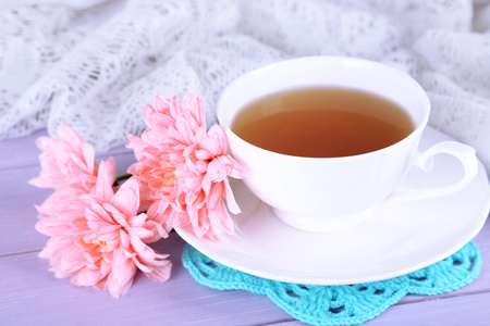 粉红色菊花和杯茶木制的桌子上
