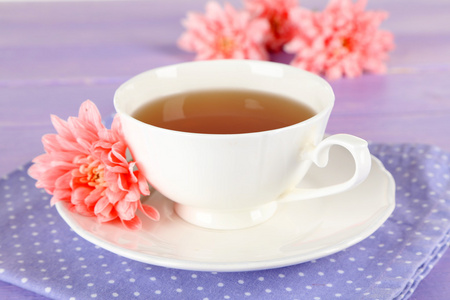 粉红色菊花和杯茶木制的桌子上