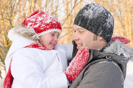 快乐的父亲和女儿在冬季公园开心