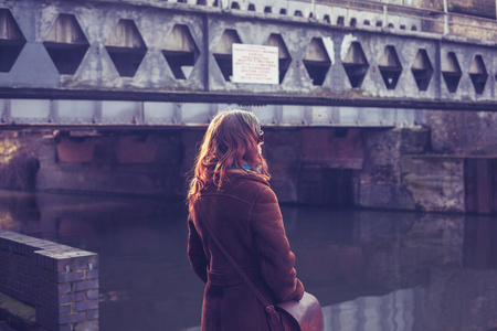 年轻的女人正看着桥和运河