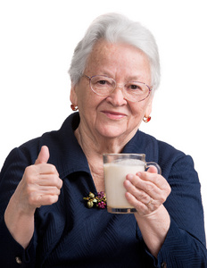 健康的老妇人拿着一杯牛奶