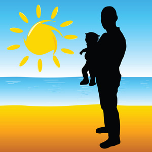 父亲抱着一个婴儿在海滩上