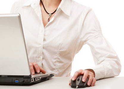 一个年轻的女子坐在一台笔记本电脑
