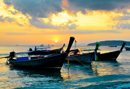 日落海滩的传统泰式船