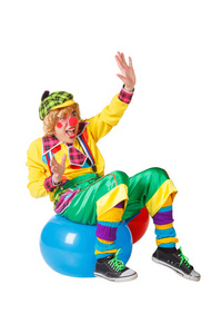 滑稽小丑坐在蓝色的球