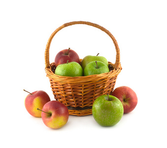 许多成熟彩色苹果在棕色的柳条编织的篮子和靠近它分离