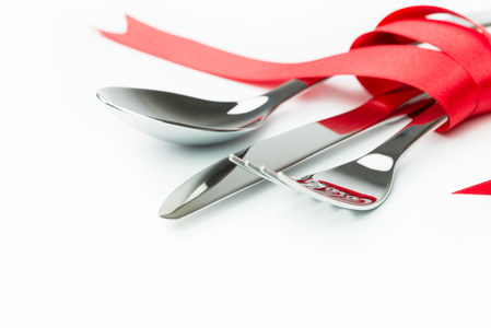 用红丝带绑的叉子，勺子和刀
