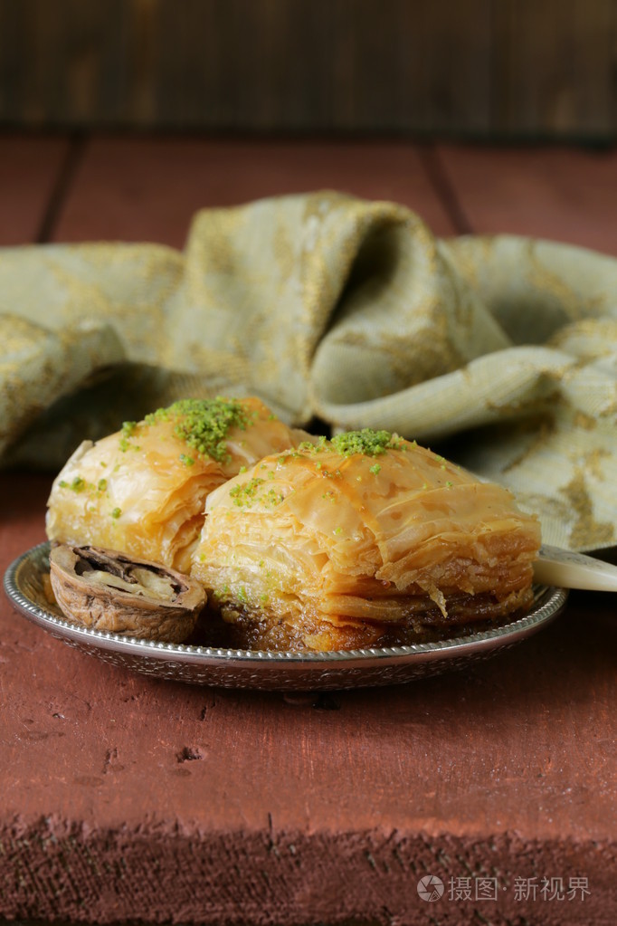 土耳其阿拉伯甜点果仁蜜饼以蜂蜜和坚果在银色的盘子上