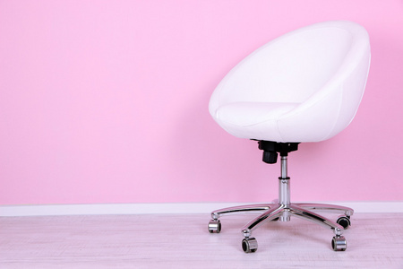 在房间里粉红色的背景上的现代椅子