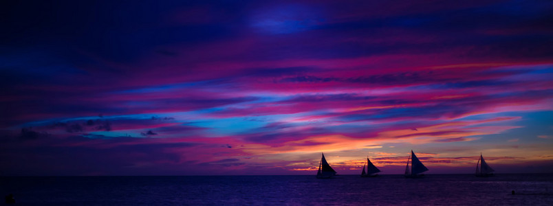 全景图的多彩美丽的日落，与在长滩岛地平线上的帆船