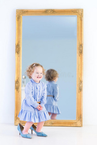 有趣的小女孩，卷发在镜子前
