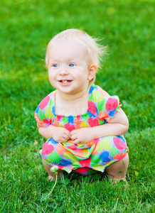 可爱有趣的小女孩坐在草地上
