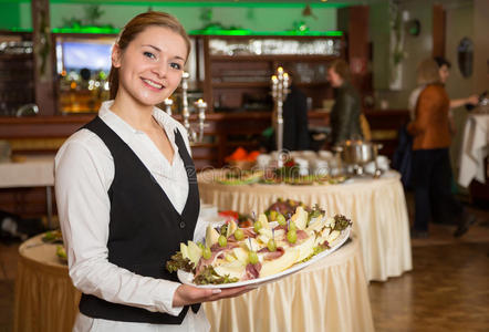 餐饮服务员工或服务员端着一盘开胃菜