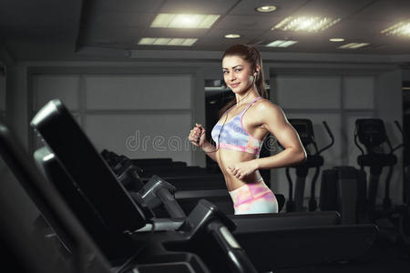 健身女孩在健身房跑步