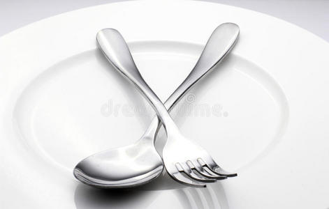勺子和叉子放在白色盘子上