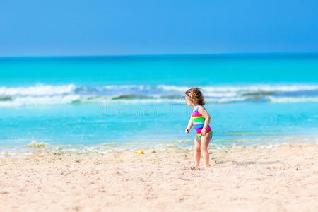 蹒跚学步的女孩在沙滩上玩耍