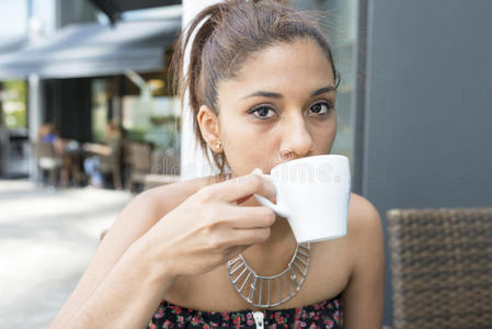 拉丁美女喝咖啡的特写肖像。