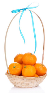 成熟香甜的橘子在柳条篮子里，白色衬底上分离