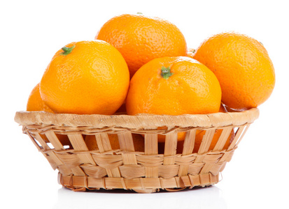 成熟香甜的橘子在柳条篮子里，白色衬底上分离