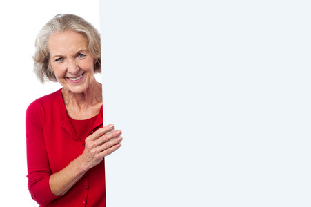 老年的妇女抱着空白广告板