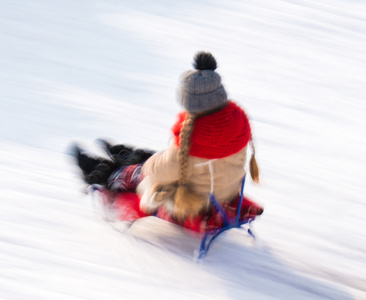 在冬天的时候滑雪橇的小女孩