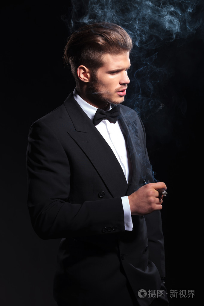 在抽着雪茄的燕尾服的时尚男人的一面