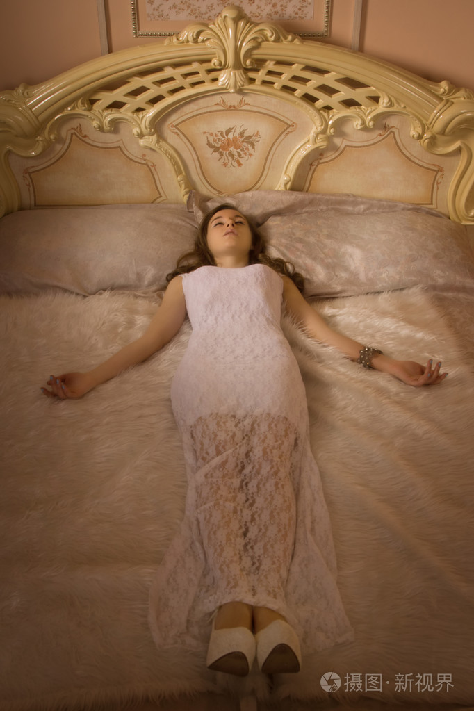 年轻优雅的女孩躺在床上