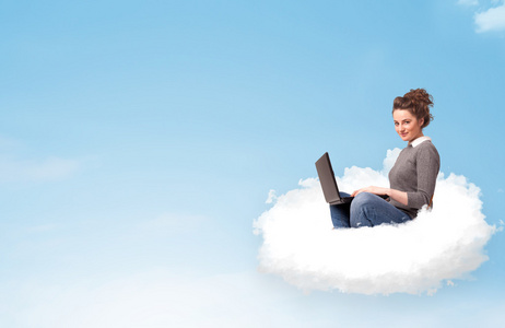 年轻女子坐在云与副本空间上的笔记本电脑