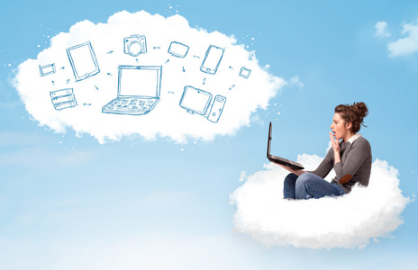 年轻的女人坐在云与便携式计算机