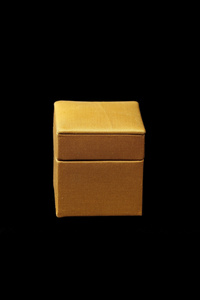 在深色背景上的黄色丝绸盒子
