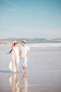 在沙滩上散步的年轻夫妇