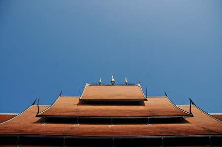 陶瓷屋顶的泰国寺庙在蓝蓝的天空下