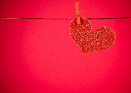 装饰红色的心挂在红色的背景，情人节的概念