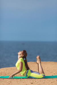 女人瑜伽。系列。室外。在海边