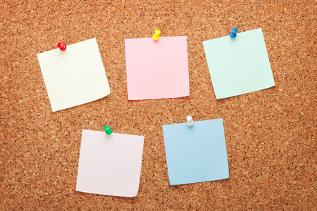 放在白板上空白纸条粘纸条上的软木板与小树, 花园背景在早晨的阳光