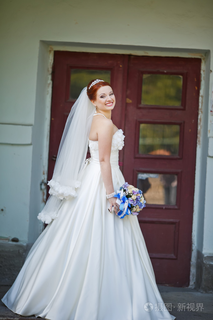 可爱的红发新娘与外面的花合影.欧洲的婚礼