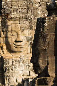 著名的微笑的脸雕像的座在吴哥巴戎寺 thom