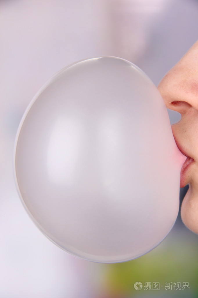 人在做泡沫与明亮的背景上嚼口香糖