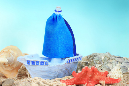 在沙子上，蓝色背景上的蓝色玩具船