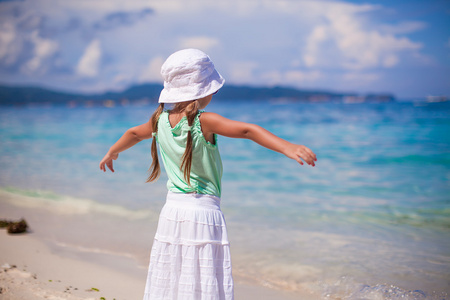 可爱快乐的小女孩，在现蕾的手散步的海滩度假