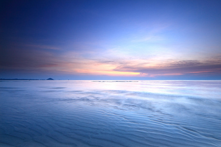 海滩日出与戏剧性的天空和大海