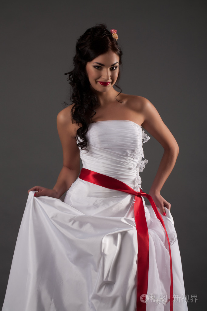 新娘穿着白色裙子系着红飘带