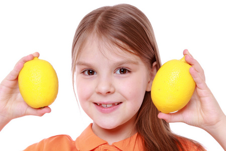小女孩用新鲜的黄色柠檬