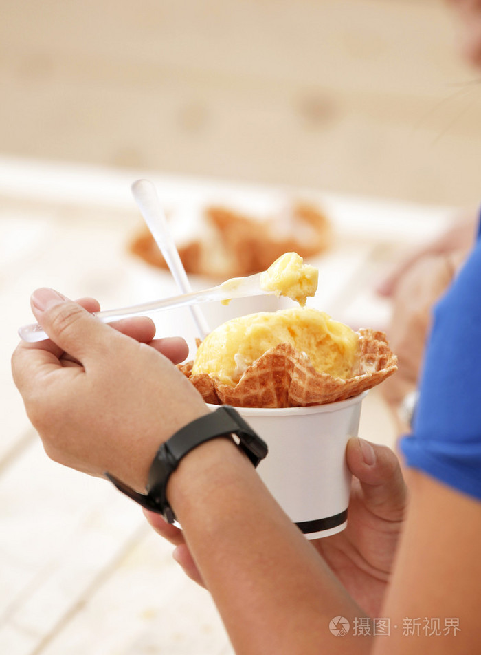 手拿着吃的冰淇淋杯