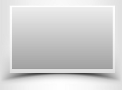 空灰色相框用阴影灰色背景下的复古相机,底片卷和空相框在灰色背景下